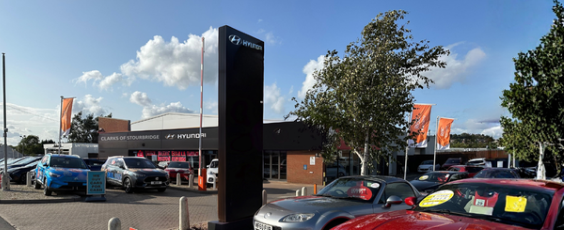 Car dealership exterior with parked vehicles and Hyundai signage.