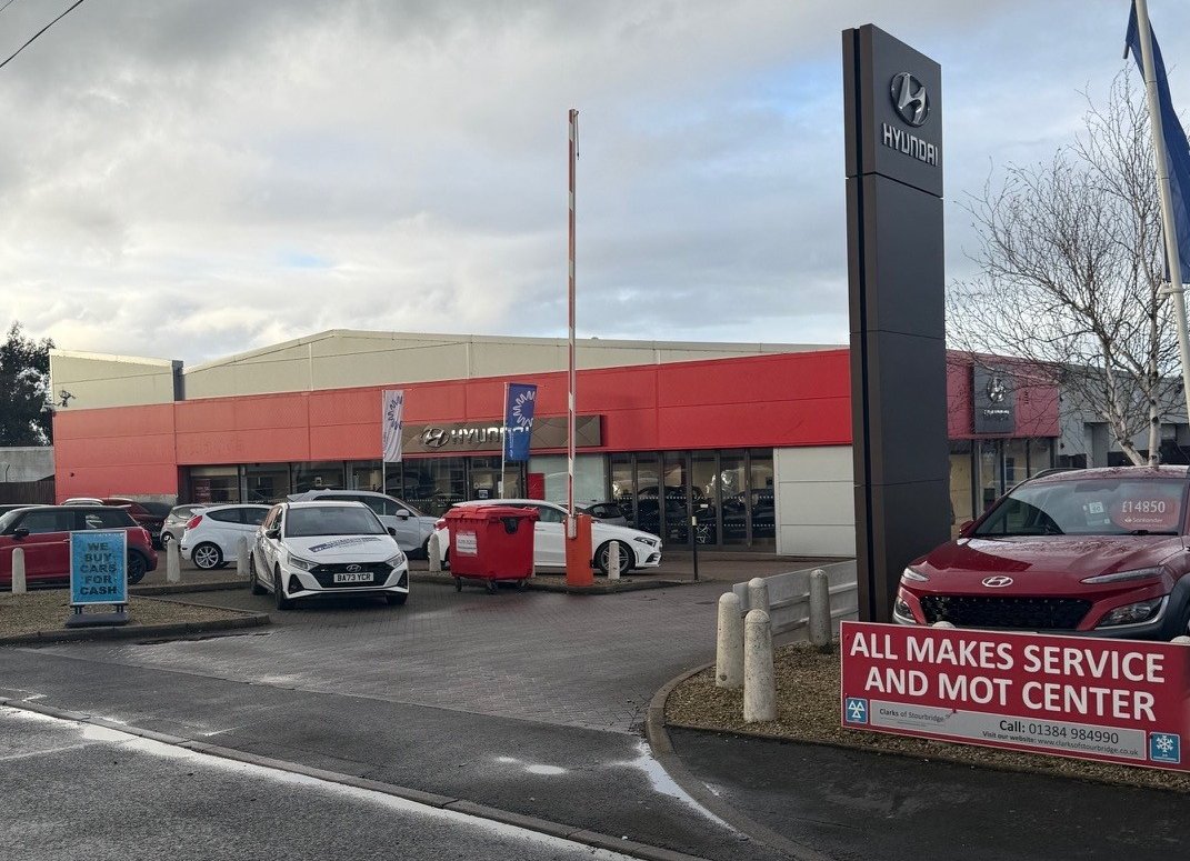 Hyundai dealership with parked cars and a service and MOT centre sign.