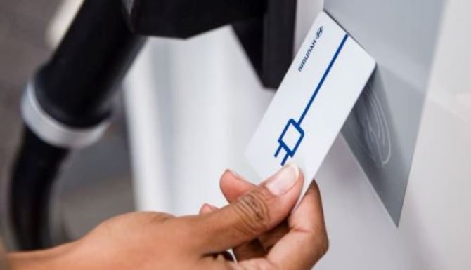 Hand inserting card into a card reader, with a charging plug symbol on the card.