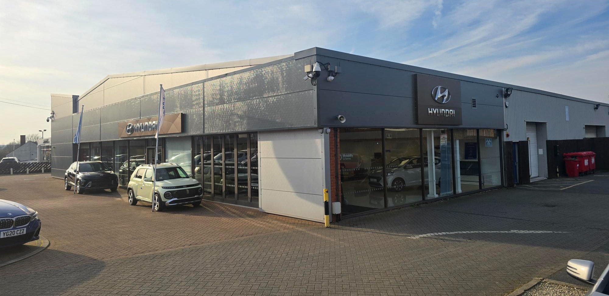 Exterior view of a Hyundai dealership with cars parked in front.